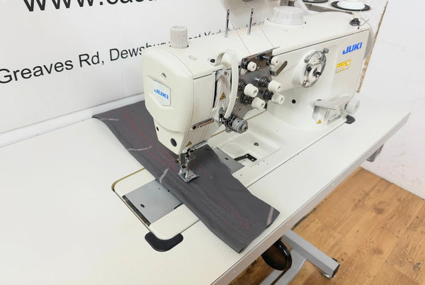 Sewing machine on a table with a visible brand logo in an indoor setting.